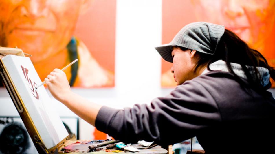 Woman in China drawing character on canvas in atelier
