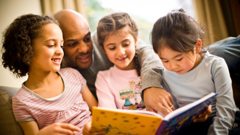 A man reading with three children