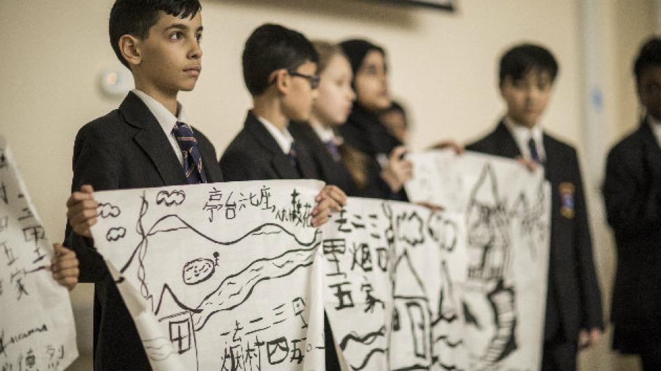 Child holding map with Chinese calligraphy.