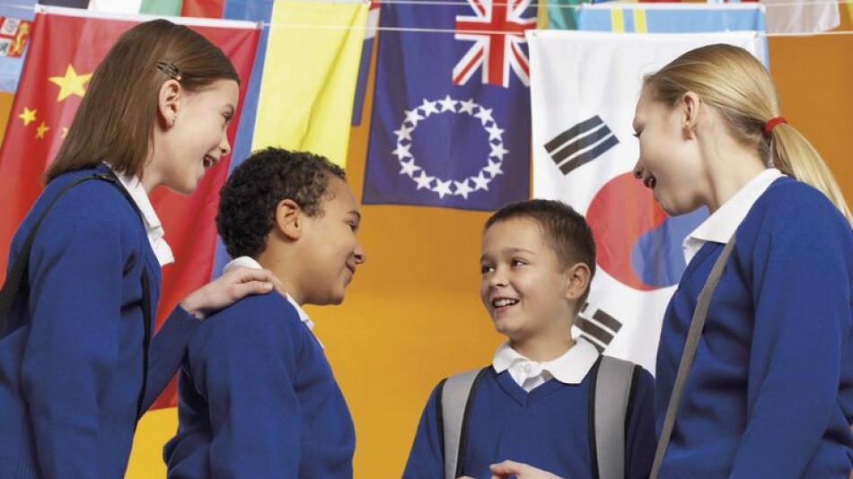 Four pupils chat together under flags of different countries