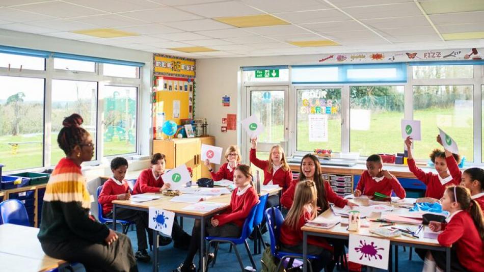 A teacher in the classroom with young pupils