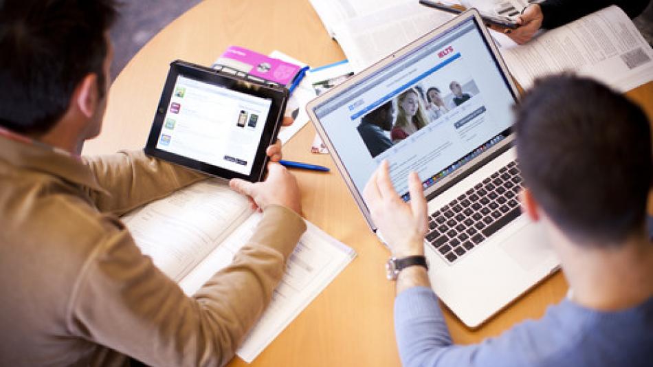 People using different devices such as iPads and laptops.