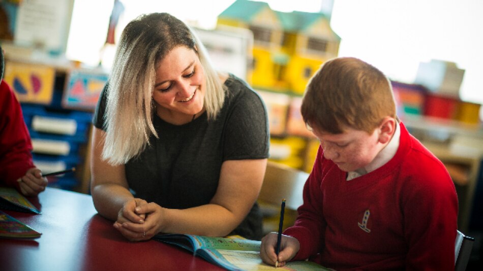 Teacher helping pupil