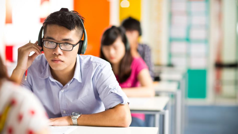 A man taking a listening test in a classroom