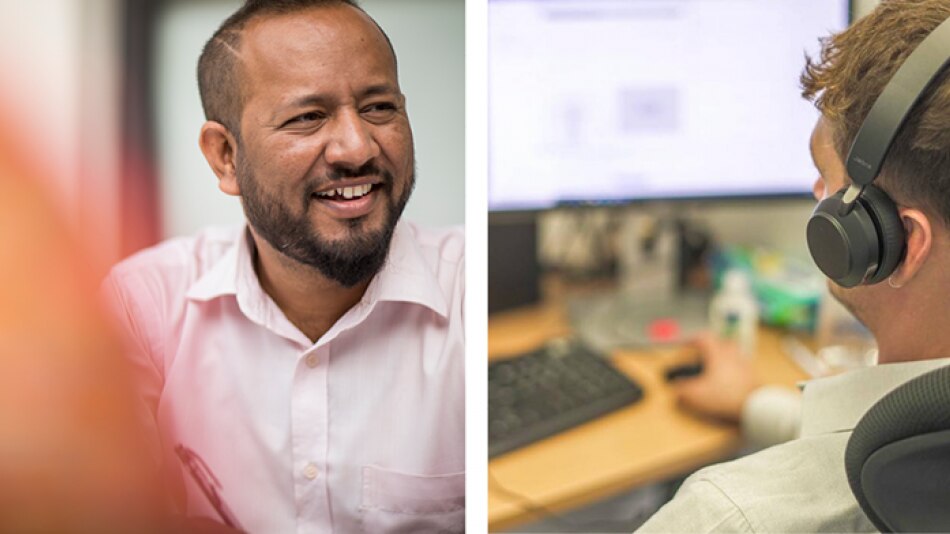 Portrait image of a man next to a man with headphones on at a computer desk