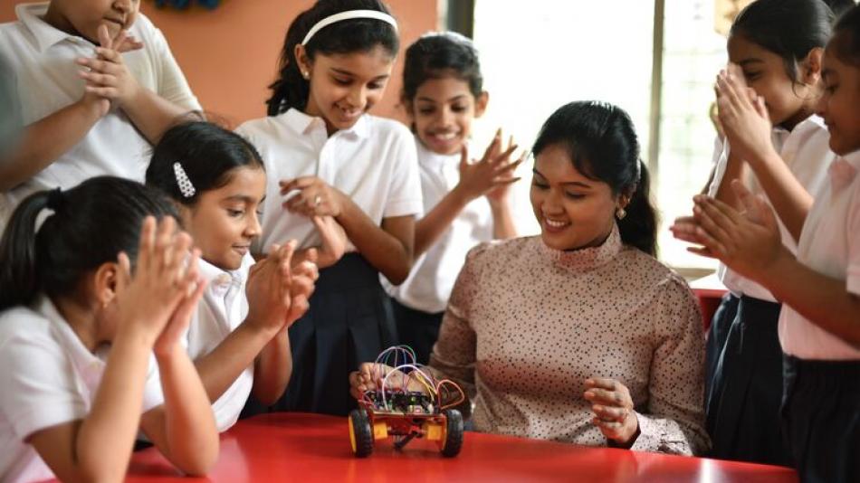 A teacher teaching students with a car model
