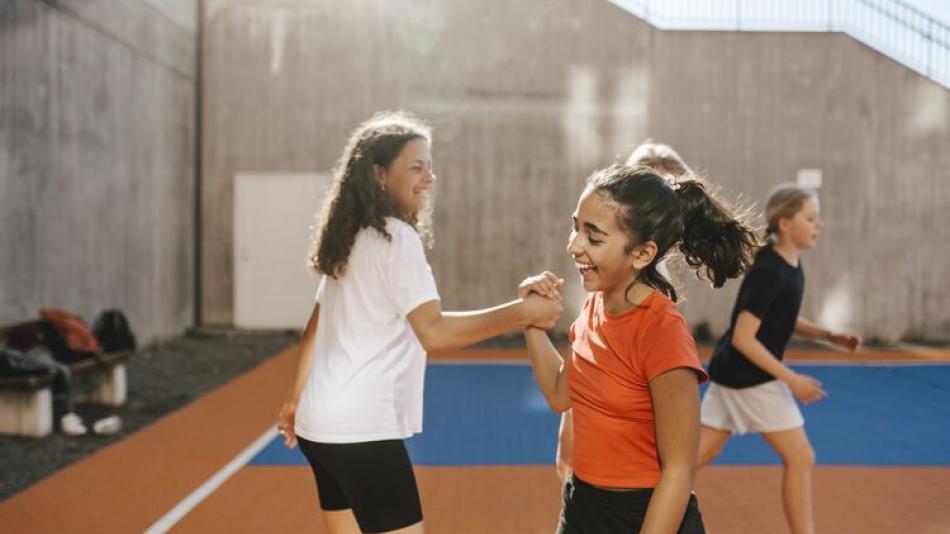 Two girls on a basketball field 