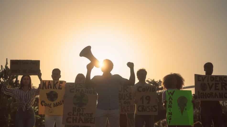 Climate activists silhouettes are shown against fading sunlight
