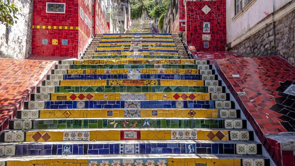 The view from the bottom of some colourful stairs with red tiled paths on either side.