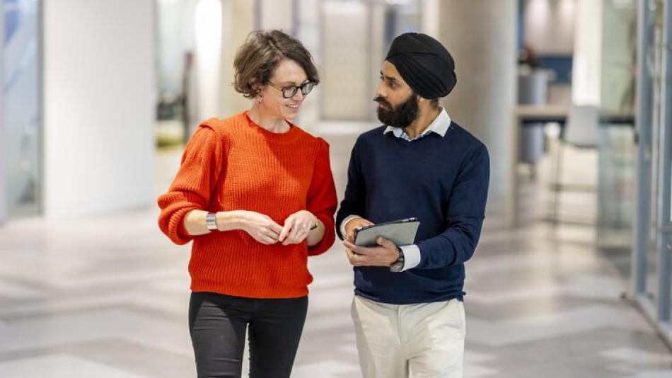 Colleagues walking across our Stratford office and having a conversation