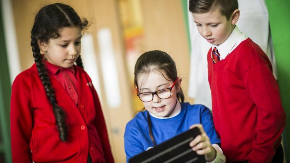 a group of pupils working together on a tablet